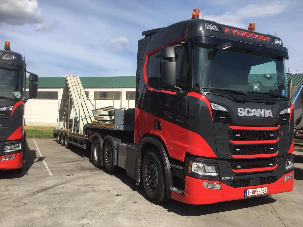 Scania-trekker van P. Verdoodt voor een lange flatbed-oplegger met prefab-elementen