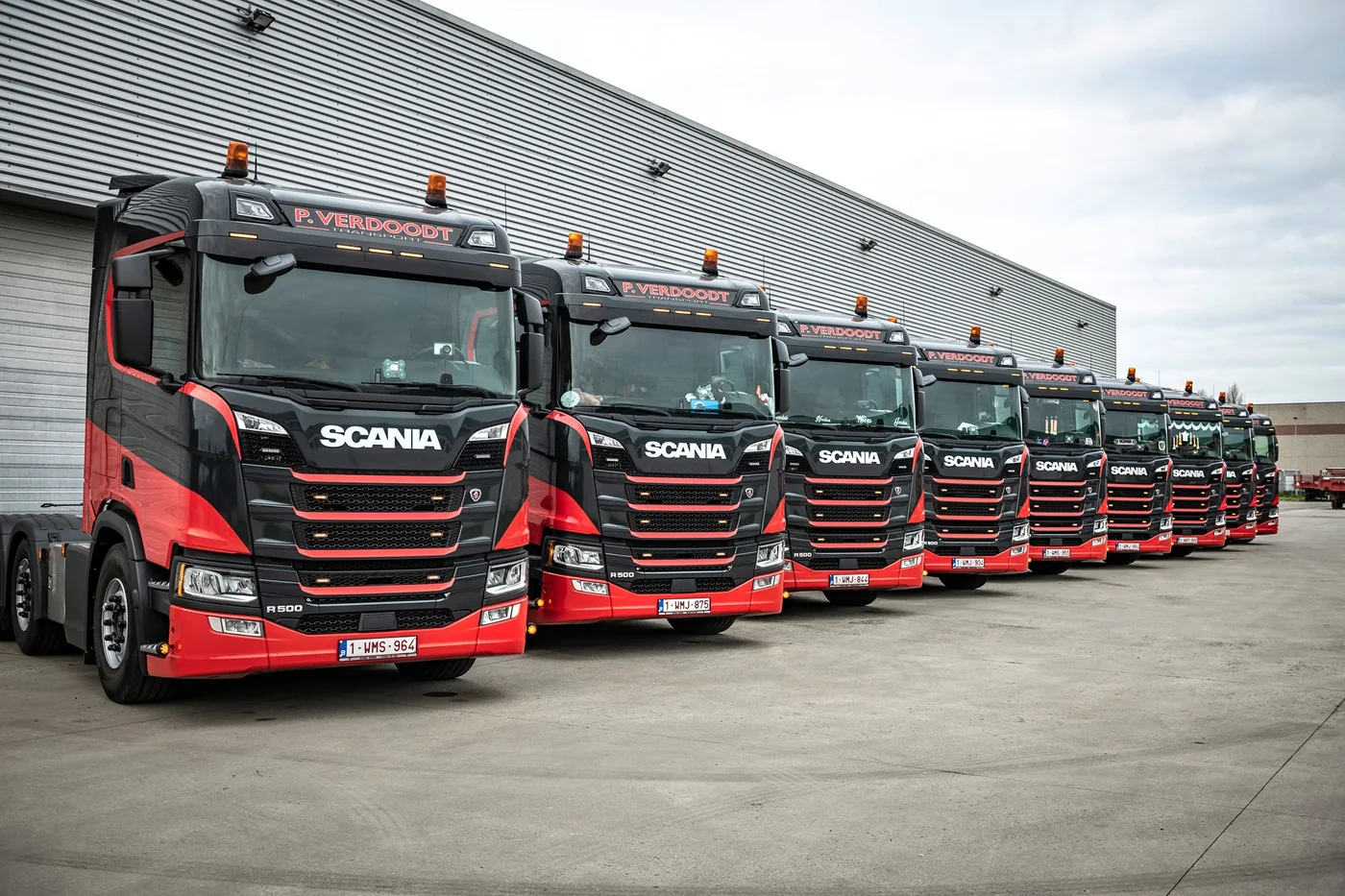 Negen zwart-rode Scania-trekkers van P. Verdoodt opgesteld voor het depot aan Hoogveld 103 in Dendermonde